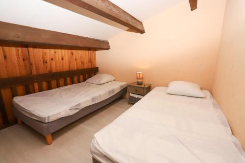 une chambre avec deux lits et une table avec une lampe dans l'établissement St Cyprien Maison 4p avec grande terrasse et jardin clos, à Saint-Cyprien