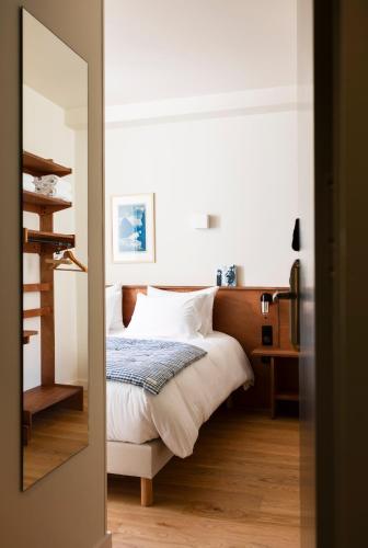 une chambre avec un lit et un miroir dans l'établissement ALFRED HOTELS Port-Vieux, à Biarritz
