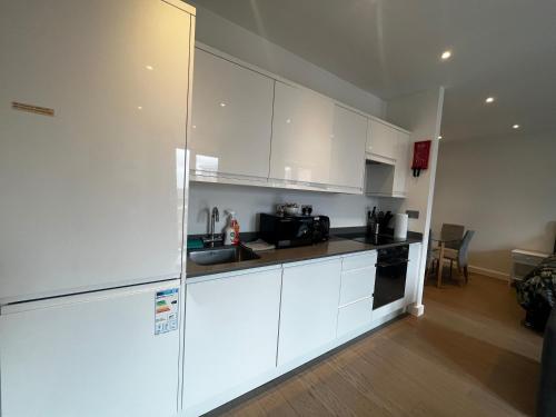 a kitchen with white cabinets and a counter top at Grosvenor Rd Studio - Sleeps 4 Pet Friendly WiFi in St. Albans