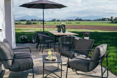 a patio with a table and chairs and an umbrella at Das Frialing in Altenmarkt an der Alz