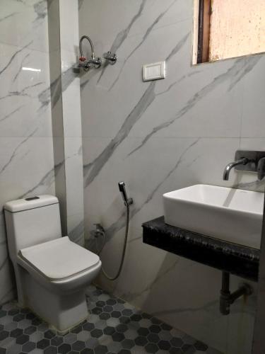 a bathroom with a white toilet and a sink at Hotel Yatri International in New Delhi