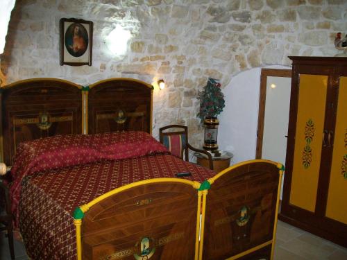 a bedroom with a bed and a stone wall at Agriturismo I Trulli Di Zio Dino in Cisternino