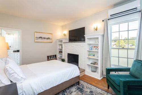 a bedroom with a bed and a fireplace and a chair at First Floor Suites at The Legacy Inn Harmony Floor in Luray
