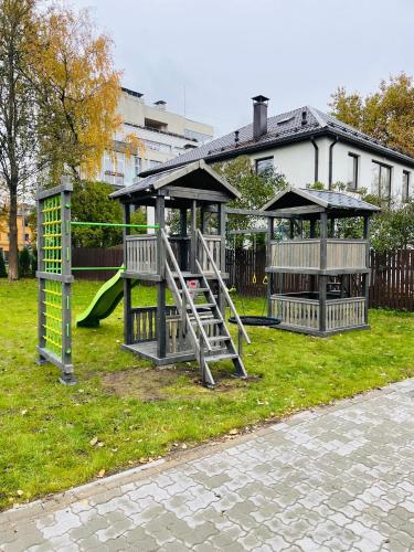 a playground with a slide and a swing set at BRIVIBAS RESIDENCE - SUNSET, free PRIVAT parking, free WIFI, self check-in in Rīga
