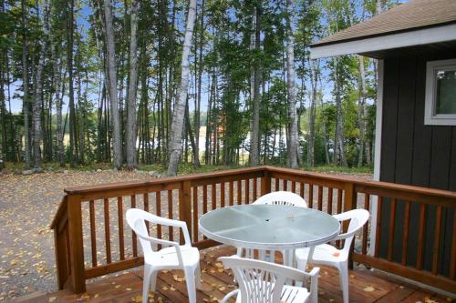 a patio with a table and chairs on a deck at Wolf Point Cabin in Boulder Junction WI in Sayner