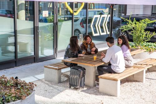 a group of people sitting at a picnic table at MEININGER Hotel Berlin East Side Gallery in Berlin