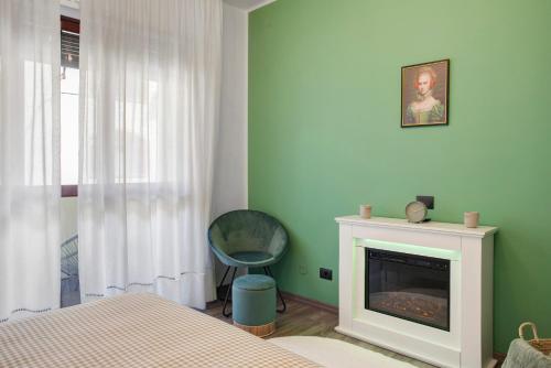 a bedroom with a fireplace and a bed and a chair at Il Rifugio di Sebi in Morbegno