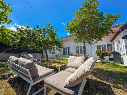 twee ligstoelen in de achtertuin van een huis bij Villa familiale proche Océan in Soulac-sur-Mer