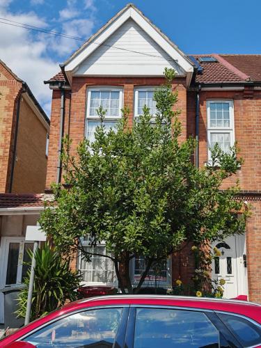 a red car parked in front of a brick house at SnoozeDen Wellesley - Near to Slough Station in Slough