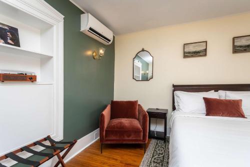 a bedroom with a bed and a chair at The Legacy Suites Collection Full Property Rental in Luray
