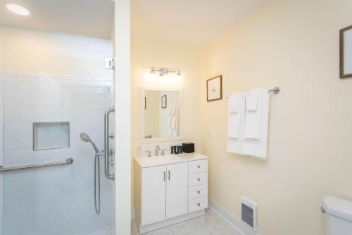 a white bathroom with a shower and a sink at The Legacy Suites Collection Full Property Rental in Luray