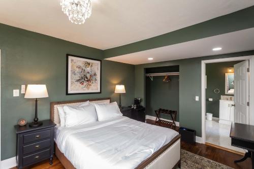a bedroom with a large white bed and green walls at The Legacy Suites Collection Full Property Rental in Luray