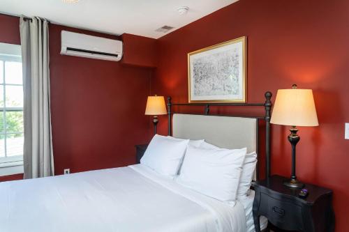 a bedroom with a white bed with red walls at The Legacy Suites Collection Full Property Rental in Luray