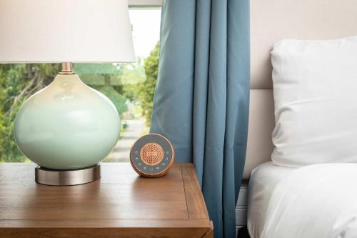a lamp on a table next to a bed at The Legacy Suites Collection Full Property Rental in Luray