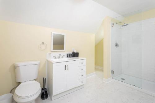 a white bathroom with a toilet and a shower at The Legacy Suites Collection Full Property Rental in Luray