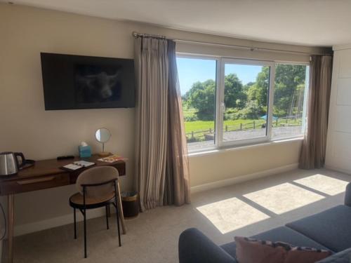 a living room with a desk and a window at White Hart Inn in Brightling