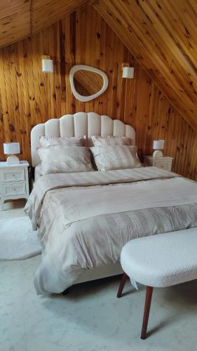 une chambre avec un grand lit blanc et une chaise dans l'établissement Maison avec borne de recharge N2, à Rolampont