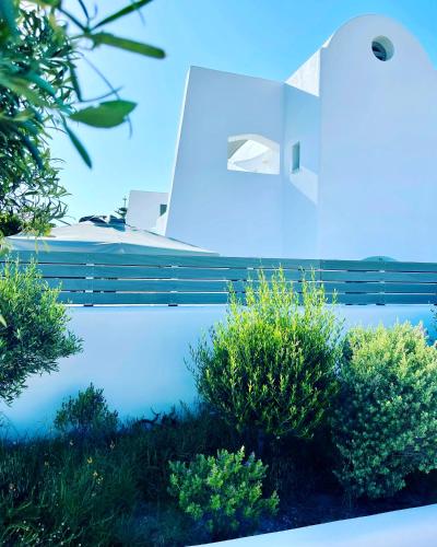 a building with bushes on the side of it at White Harmony Suites in Megalokhori