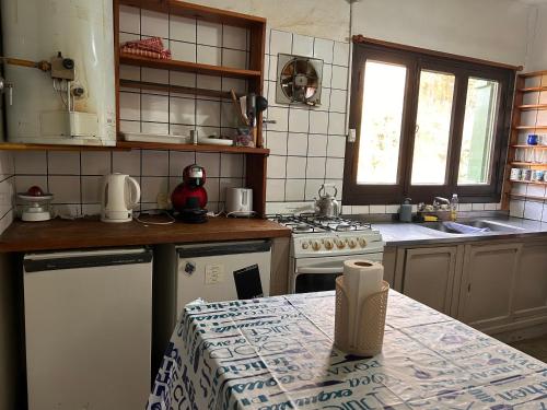 una cucina con piano cottura e bancone con tavolo di Casa Azucena a El Bolsón