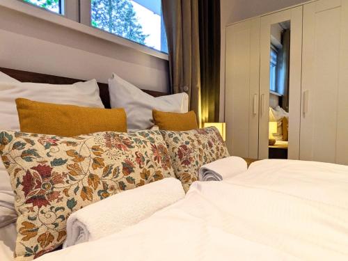 a bedroom with a bed with pillows and a window at SB Apartment with Sauna in Kołobrzeg