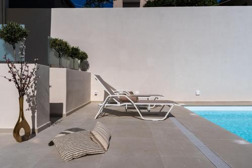 a chair sitting on a patio next to a pool at Selected Suites in Chania Town