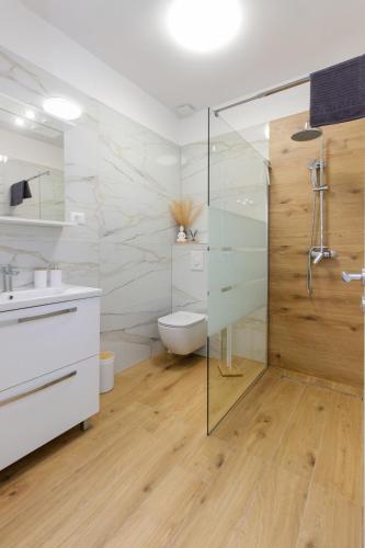 a bathroom with a glass shower and a toilet at Trogirski san in Trogir