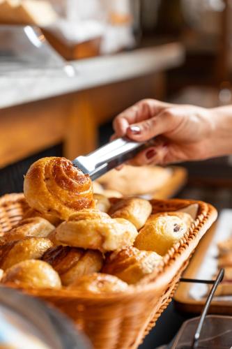 a person holding a cell phone next to a basket of bread at Sophia Hotel By OxoHotel in Cartagena de Indias