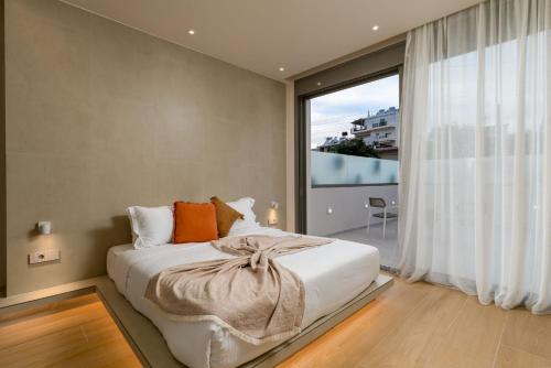 a bedroom with a bed and a large window at Selected Suites in Chania Town