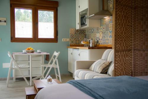 a living room with a couch and a kitchen at Apartamentos PENAQUENTE in Porto de Espasante