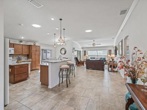 Una cocina abierta y una sala de estar con mostrador y sillas. en 1068 Z4B VILLAGE OF PINE RIDGE by REMAX Premier, en The Villages