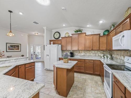 Una cocina con gabinetes de madera y un refrigerador blanco. en 1068 Z4B VILLAGE OF PINE RIDGE by REMAX Premier, en The Villages