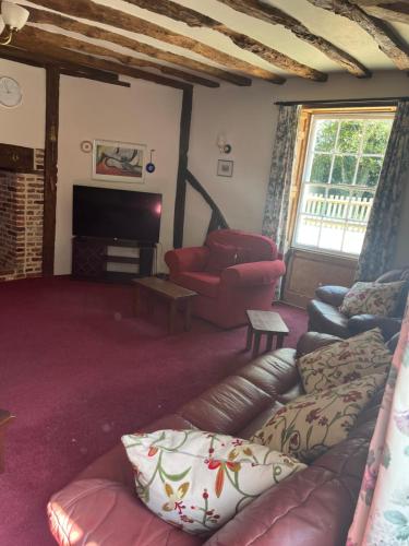 a living room with a couch and a chair at Chilton Manor House in Murston
