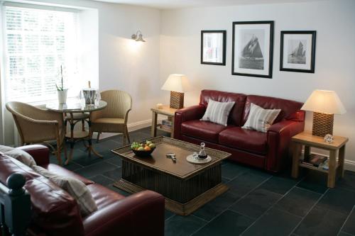 a living room with a red couch and a table at Cary Arms & Spa in Torquay