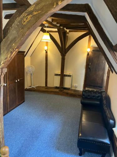 a living room with a black leather bench in a room at Chilton Manor House in Murston