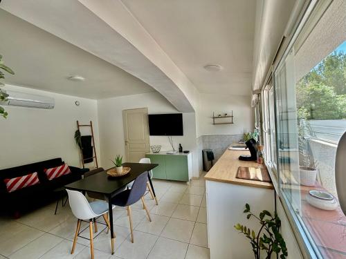 a kitchen and living room with a table and chairs at Joli Appartement au centre de carry le rouet in Carry-le-Rouet
