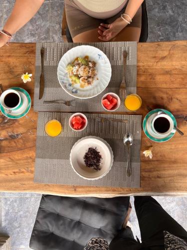 a table with two plates of food and cups of coffee at Niraka Home in Bebandem
