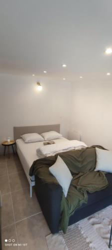 une chambre avec deux lits avec draps blancs et oreillers dans l'établissement Entre Bordeaux & Arcachon, à Cestas