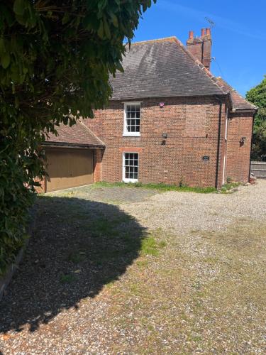 an old brick building with a garage and a driveway at Chilton Manor House in Murston