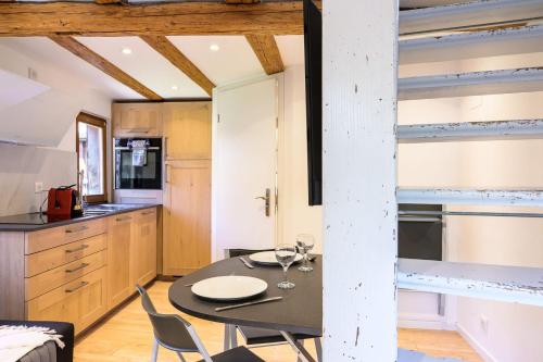 une cuisine et une salle à manger avec une table et des chaises dans l'établissement Maisonnette Alsacienne en plein coeur de Turckheim, à Turckheim