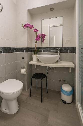 a bathroom with a sink and a toilet and a mirror at NAPOLI VIBES Rooms in Naples