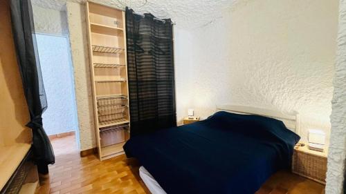 Un dormitorio con una cama azul y una ventana. en Studio Cocody 8 LUMIO, en Lumio