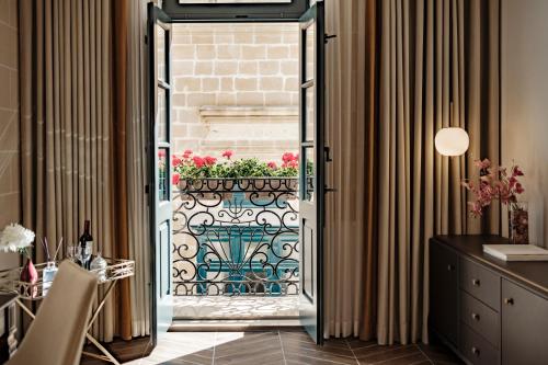 a door leading to a patio with a flower planter at 1926 La Galerie Boutique Art Suites in Valletta