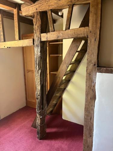 a loft bed in a room with wooden beams at Chilton Manor House in Murston