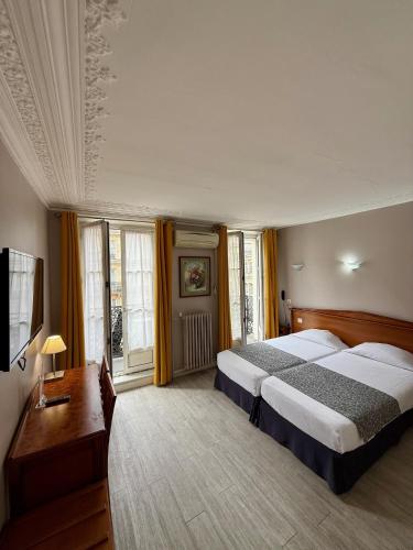 - une chambre avec 2 lits, un bureau et des fenêtres dans l'établissement New Hôtel Gare Du Nord, à Paris