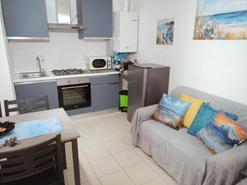 a living room with a couch and a kitchen at Carmen House in Grottammare