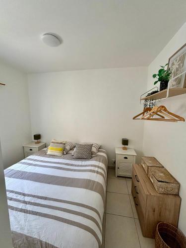 une chambre avec un lit et deux tables de nuit dans l'établissement Joli Appartement au centre de carry le rouet, à Carry-le-Rouet