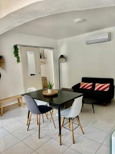 un salon avec une table et des chaises noires dans l'établissement Joli Appartement au centre de carry le rouet, à Carry-le-Rouet