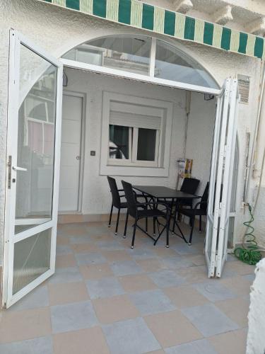 an open patio door with a table and chairs at Bungalow con barbacoa in Torrevieja