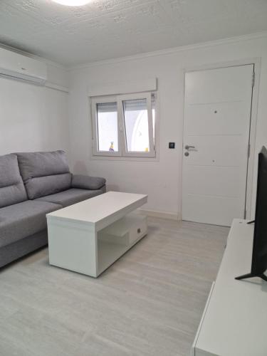 a living room with a couch and a table at Bungalow con barbacoa in Torrevieja