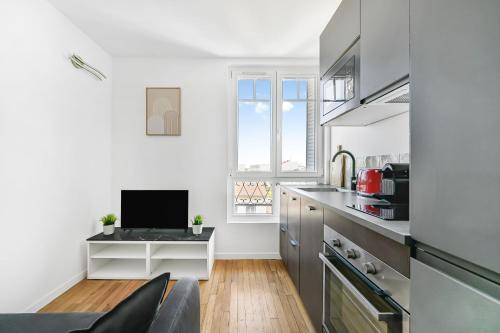 a kitchen with a desk with a computer on it at Sublime appart La Défense Paris Gare 2Pers in Nanterre